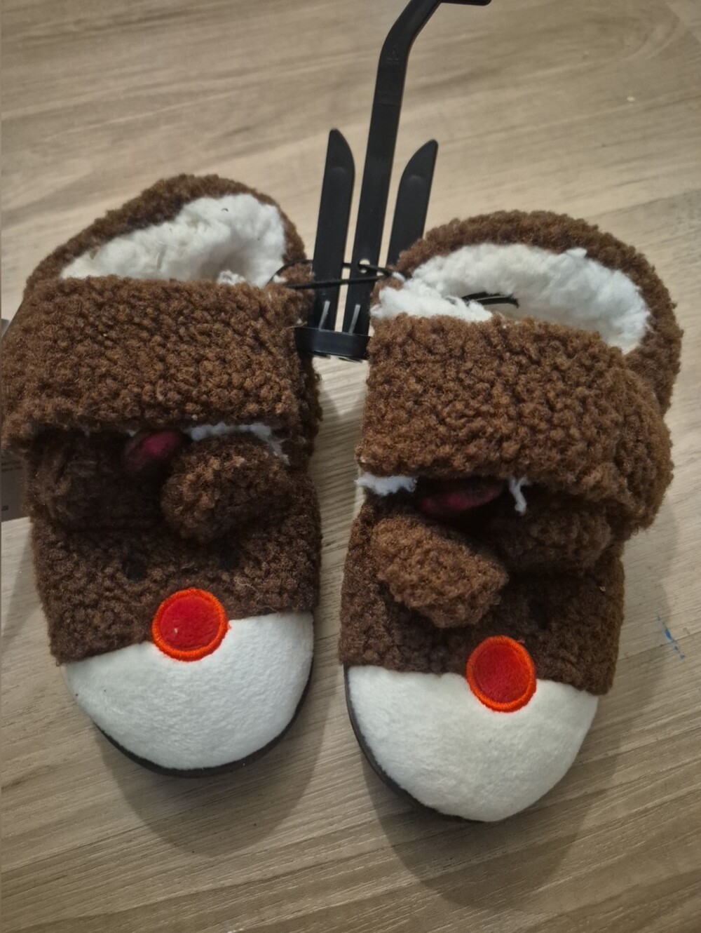fuzzy, brown reindeer-themed holiday slippers with a white snout & red nose deer